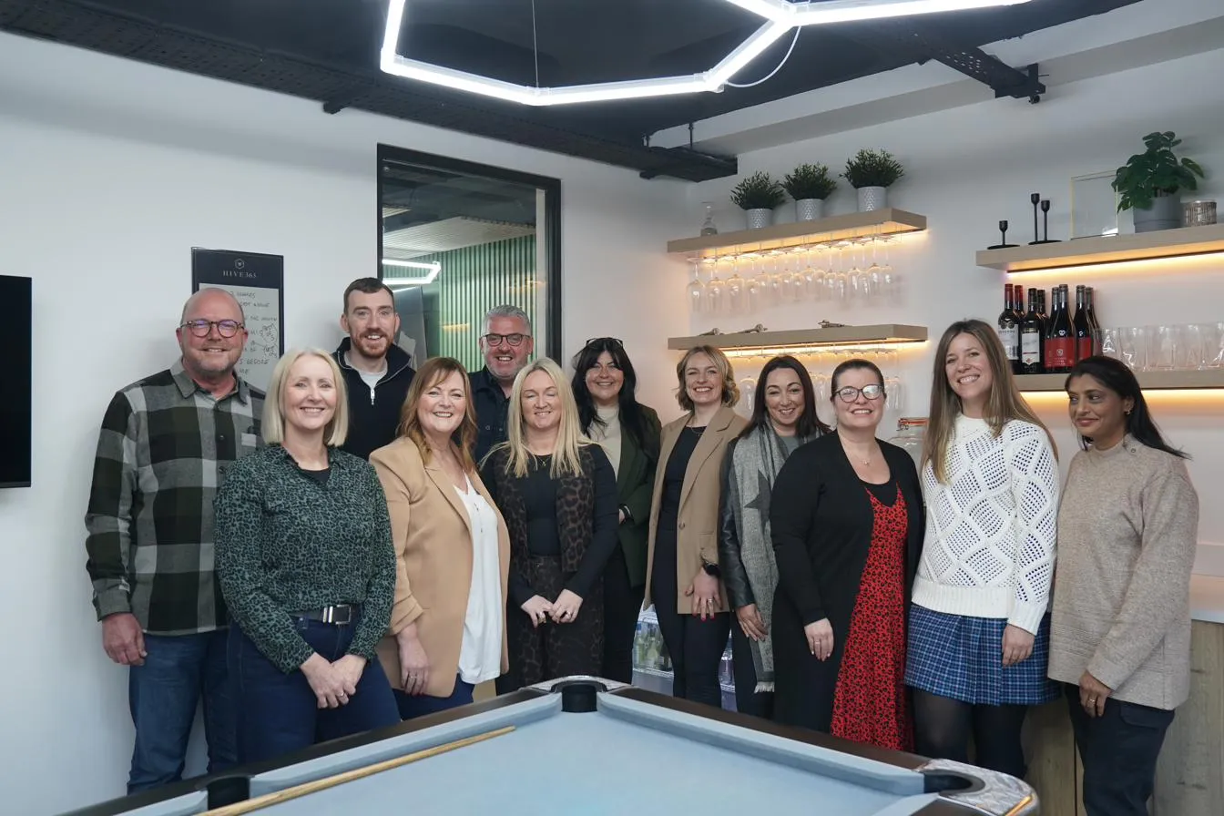 Group photo by the pool table under the hexagon lights